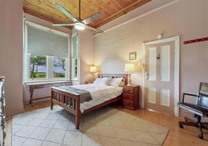 a bedroom with a bed with a ceiling fan and a window at Cork Hill Retreat in Cape Bridgewater
