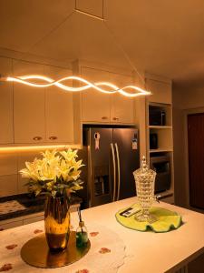 a kitchen with a counter with a vase of yellow flowers at diRoma Luxo Oficial Apt mais diRoma Acqua Park e Splash e Slide , 3 parques Aquáticos , Roupa de Cama e Toalhas, Parcelamos até 12x no Cartão de Crédito sem Juros , Aceitamos Pet in Caldas Novas