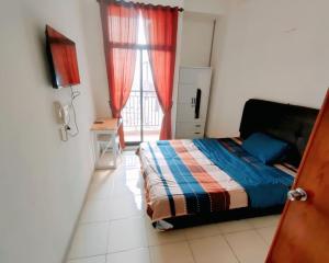 a bedroom with a bed and a window with red curtains at Dave Apartment in Pondoktjina Tiga +2 photos