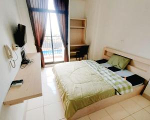 a bedroom with a bed in a room with a window at Dave Apartment in Pondoktjina Tiga