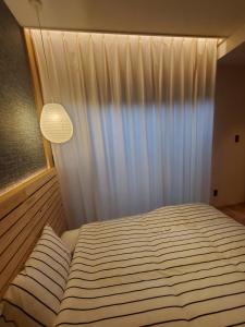 a bedroom with a bed with a white curtain at tomariel in Ō-shima +1 photo