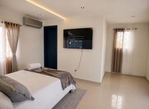 a bedroom with a bed and a television on the wall at Villa renacer in Baní +32 photos