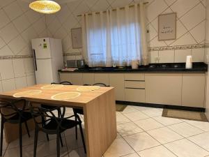 a kitchen with a table with chairs and a refrigerator at Casa aconchego Casa ampla e completa no centro in Naviraí