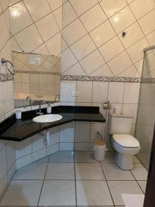 a bathroom with a toilet and a sink at Casa aconchego Casa ampla e completa no centro in Naviraí +17 photos
