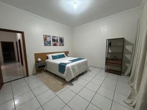 a bedroom with a bed and a mirror at Casa aconchego Casa ampla e completa no centro in Naviraí