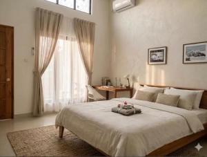 a bedroom with a bed and a desk and a window at Kooka Residence Surabaya in Surabaya