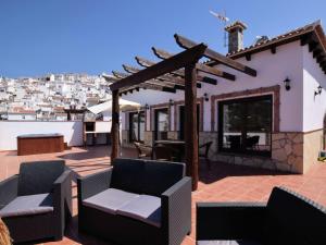 a patio with chairs and a pergola at Beautiful villa with jacuzzi in Canillas de Albaida