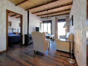 a living room with a white chair and a bedroom at Beautiful villa with jacuzzi in Canillas de Albaida