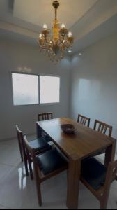 a dining room table with chairs and a chandelier at La résidence des lions in Thiès