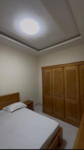 a bedroom with a bed and wooden cabinets at La résidence des lions in Thiès +6 photos