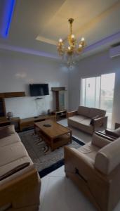 a living room with a couch and a chandelier at La résidence des lions in Thiès