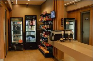 a grocery store with a cash register and two refrigerators at Studio próximo a UFU Sta Monica e Center shopping in Uberlândia