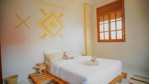 a bedroom with a white bed and a window at Azul Berg Hostel in Tamraght Ouzdar +88 photos