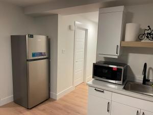 a kitchen with a refrigerator and a microwave at Orgive Suite - Private 1 Bedroom Apartment in Riverview