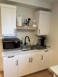 a kitchen with white cabinets and a sink and a microwave at Orgive Suite - Private 1 Bedroom Apartment in Riverview +18 photos