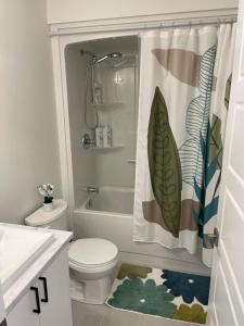 a bathroom with a toilet and a shower curtain at Orgive Suite - Private 1 Bedroom Apartment in Riverview