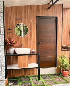 a bathroom with a sink and a wooden door at Ginger Villa Farmstay, Thodupuzha in Idukki