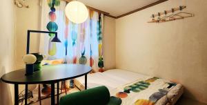 a small room with a table and a bed and a window at 낙원파크포도홈 in P'ungnyŏn-gol