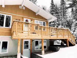 a wooden deck on the side of a house at Chalet familial, idéalement situé, billard-table-babyfoot-arcade in Saint-Faustin