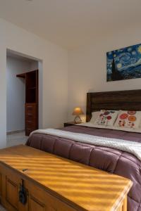 a bedroom with a large bed with a wooden headboard at Días tranquilos dentro de El Refugio in San José el Alto