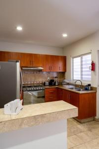 a kitchen with wooden cabinets and a stainless steel refrigerator at Días tranquilos dentro de El Refugio in San José el Alto