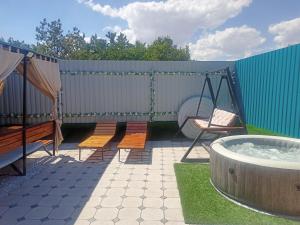 a backyard with a hot tub and a swing at Laguna Relax in Balqash