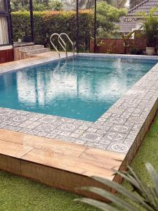 a swimming pool in a yard with a stone path around it at Ginger Villa Farmstay, Thodupuzha in Idukki