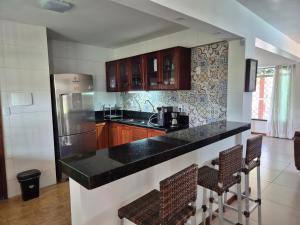a kitchen with a black counter top and wooden cabinets at Casa em Salinas in Salinópolis