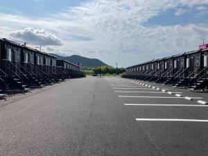 an empty parking lot with rows of train cars at HOTEL R9 The Yard Hikari in Hikari