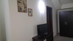 a room with a flat screen tv and a black cabinet at Vikeya Guest House in Sapareva Banya