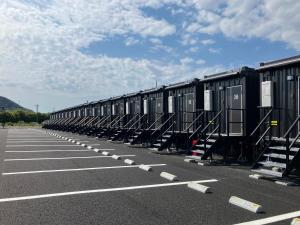a row of black containers sitting in a parking lot at HOTEL R9 The Yard Hikari in Hikari