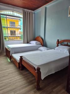 two beds in a room with a window at Casa em Salinas in Salinópolis +12 photos