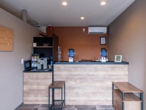 a restaurant with a counter and two stools at HOTEL R9 The Yard Hikari in Hikari