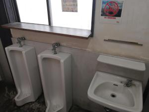 a bathroom with two urinals and a sink at 駅舎泊ラッセルイン in Hirakawa +13 photos