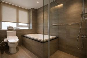 a bathroom with a toilet and a glass shower at P&F Hotel in Taichung