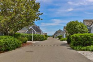 a driveway in a residential neighborhood with houses at Hydrangea Lane Beach Cottage in Mashpee