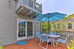 a patio with a table and chairs and an umbrella at Hydrangea Lane Beach Cottage in Mashpee +28 photos