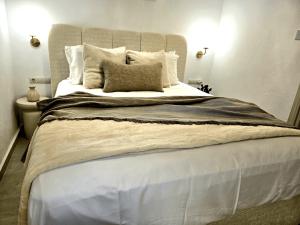 a large bed with white sheets and pillows at Ktima Voulme in Kavála