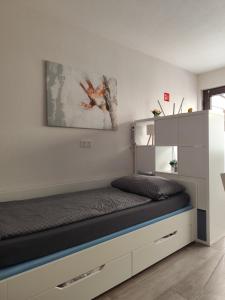 a bed in a bedroom with a white wall at Ferienwohnung Bamberger mit Wintergarten Schmalkalden in Schmalkalden