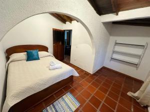 a bedroom with a bed in a room with an archway at Casa Solar in Guatapé