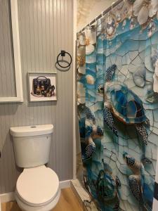 a bathroom with a toilet and a turtle shower curtain at Berlins Cozy Apartment Pets Welcome in North Little Rock