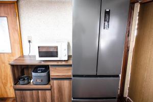 a kitchen with a stainless steel refrigerator and a microwave at 白灯-Hakuto- Muikamachi in Minami Uonuma +18 photos