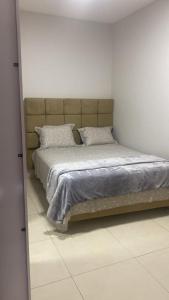 a bedroom with a bed in a white room at Lar com piscina in Primavera do Leste +34 photos