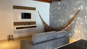 a living room with a couch and a tv at Lar com piscina in Primavera do Leste