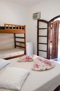 a bedroom with two bunk beds with white sheets at Pousada dos Pescadores in Bertioga +34 photos