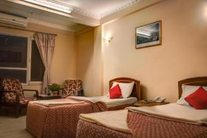 a hotel room with two beds with red pillows at Hotel Kamal in Kathmandu