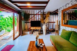 a living room with a couch and a tv at Eywa Retreat in Uluwatu