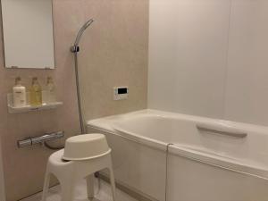 a bathroom with a white tub and a white stool at Yanagiya Iri in Nakatsugawa +11 photos