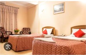 a hotel room with two beds with red pillows at Hotel Kamal in Kathmandu