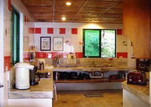 a kitchen with red and white tiled walls at Oceanside Villa in Puerto Galera